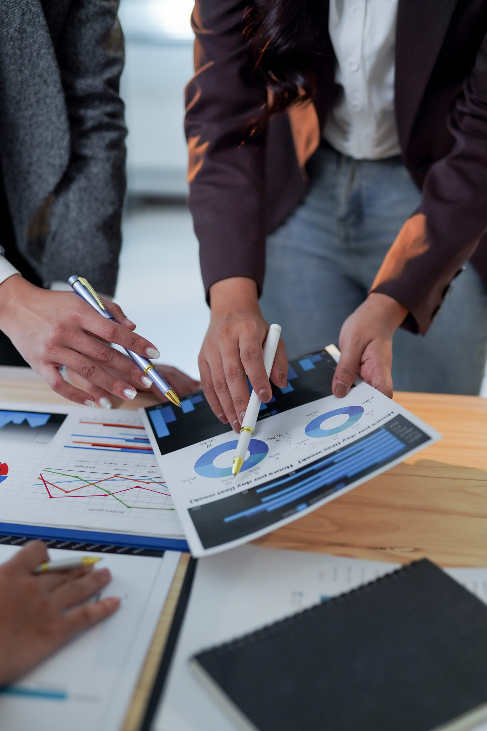 Business team analyzing financial charts and graphs during a meeting, discussing company performance and making strategic decisions