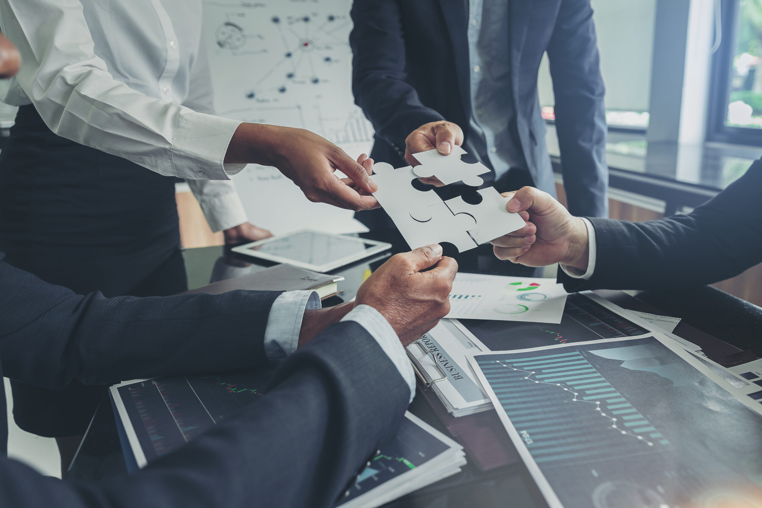 Business people putting connect jigsaw puzzle. Team work and strategic solution concept. Financial Reporting & Analysis